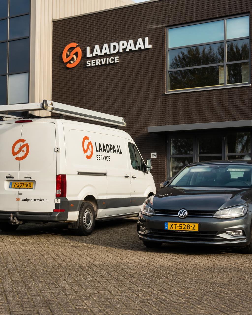Witte bedrijfsbus en personenauto op een Nederlands bedrijfsterrein