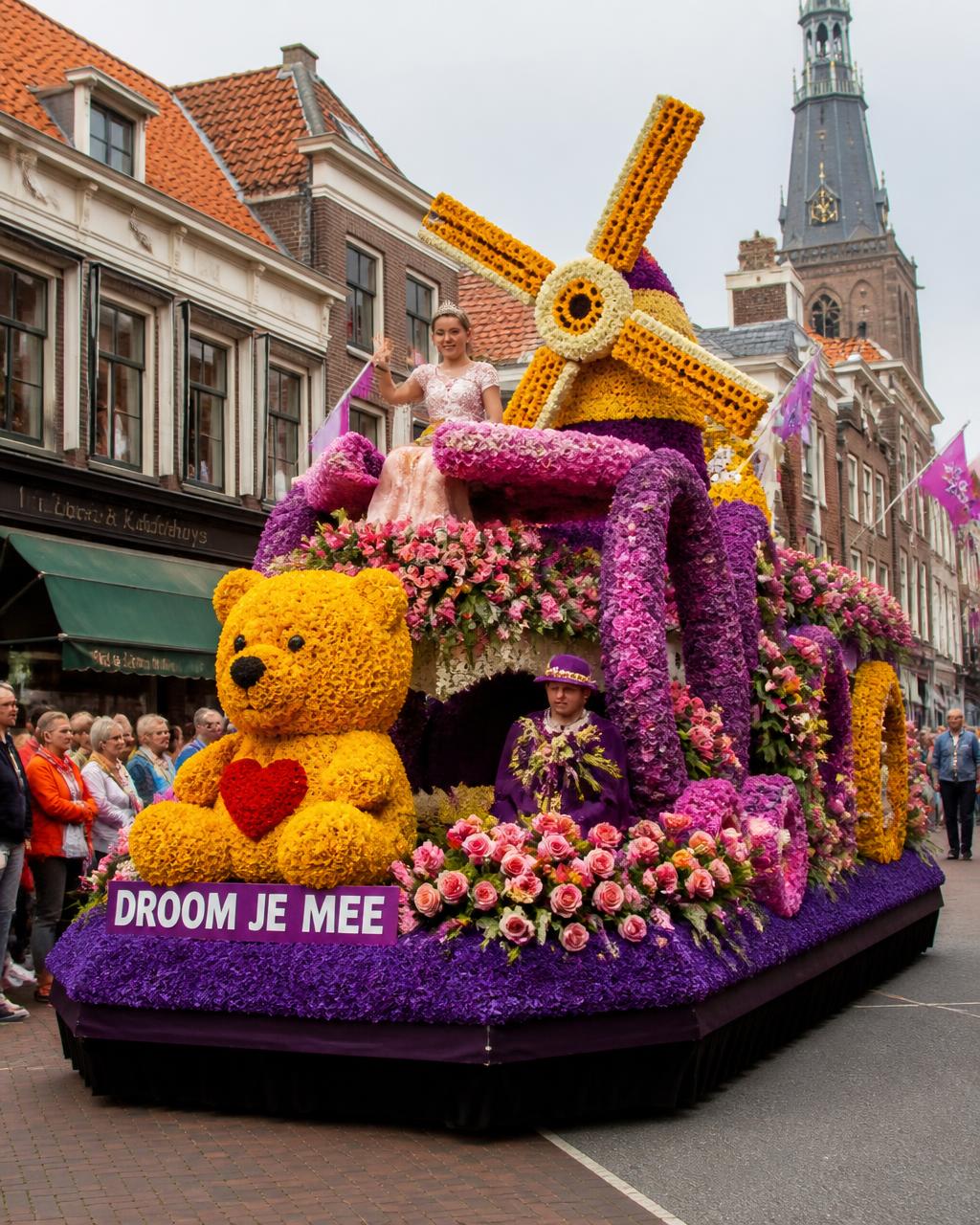 Rijk versierde praalwagen met bloemen in een optocht door een Nederlandse straat